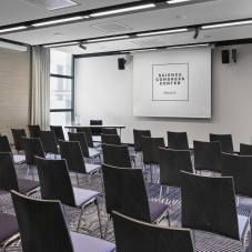 Seminarraum im Science Congress Center Munich mit schwarzen Stühlen, moderner Beleuchtung und Leinwand für Präsentationen.