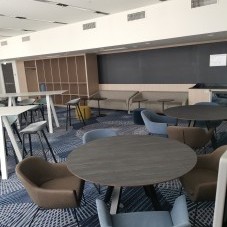Moderner Lounge-Bereich im Science Congress Center Munich mit bequemen Sesseln, runden Tischen und stilvollem Teppichdesign.