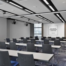 Moderner Konferenzraum im Science Congress Center Munich mit Reihenbestuhlung, Tischen und Leinwand für Präsentationen.